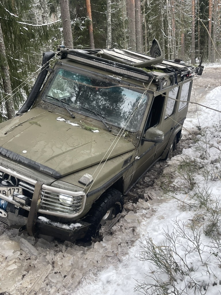 Застрявший в снегу автомобиль в зимнем лесу, Ленобласть